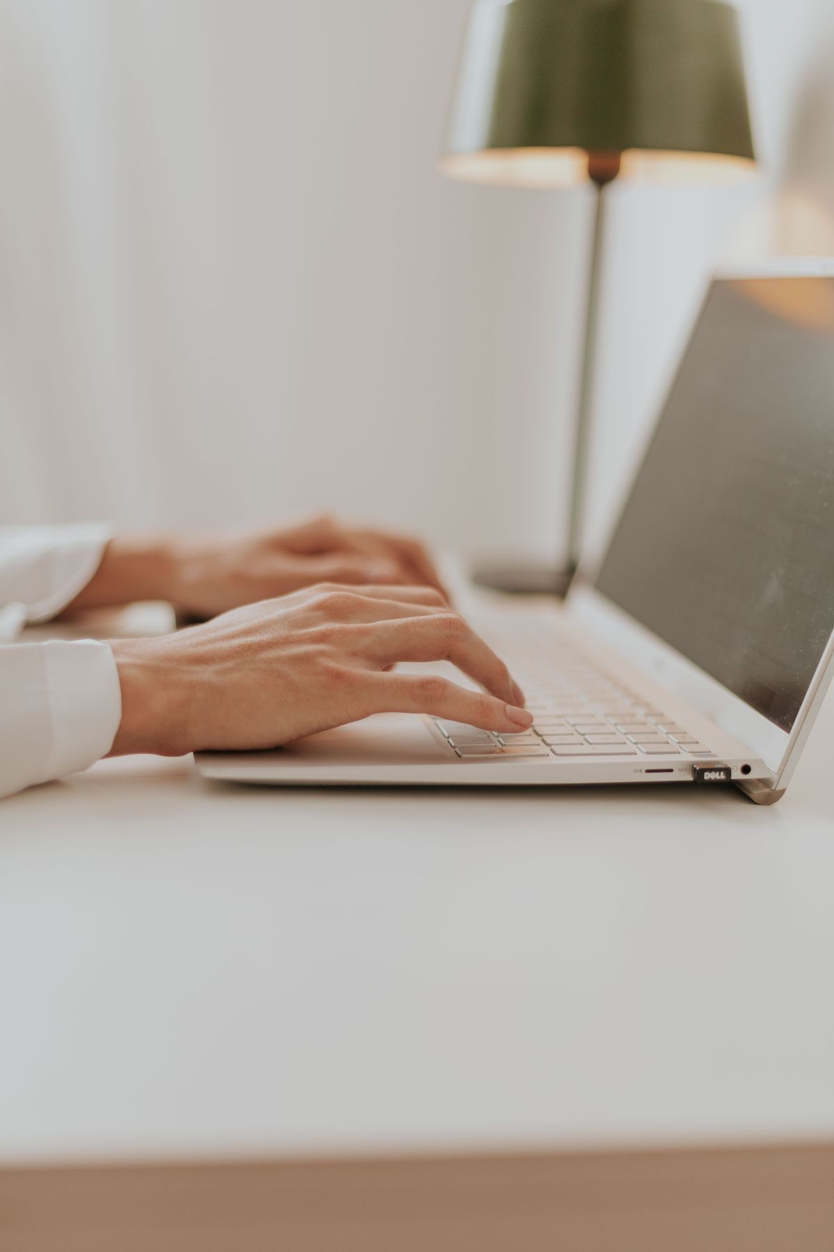 Close-up of hands typing on a laptop keyboard